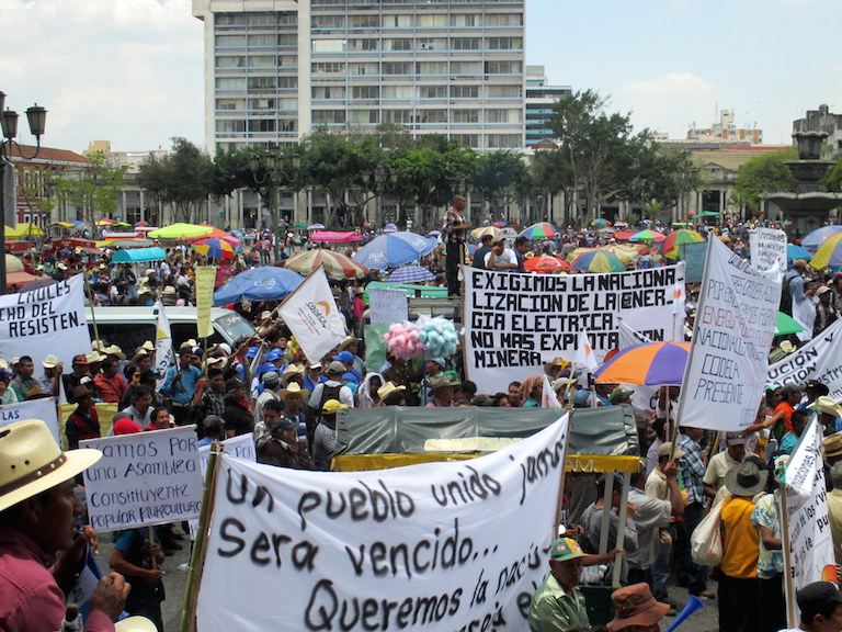 A crowd gathers at a May 20 march and rally in Guatemala City over recent revelations of widespread government corruption. One of the banners calls for the nationalization of electrical energy and a halt to mining. Photo by Sandra Cuffe.